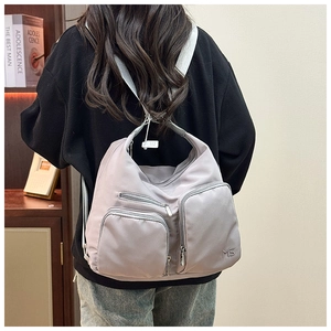 Detailansicht eines lila Funktionsrucksacks mit mehreren Taschen aus Nylon am Modell