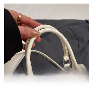 Detailed macro view of white PU leather bag with relief texture and pearl charm