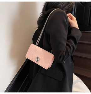 Detail view of light pink fish-scale textured crossbody bag with silver chain and lock
