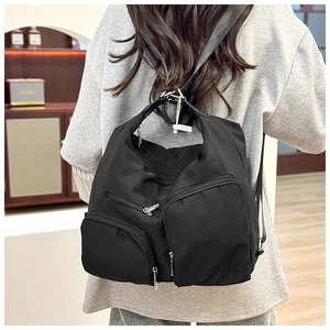 Detaillierte Nahaufnahme eines schwarzen Nylon-Rucksacks mit vielen Taschen und Reißverschlüssen