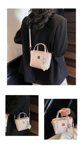 Dettaglio mini borsa a secchiello in vernice rosa con ciondolo a cuore e logo metallico
