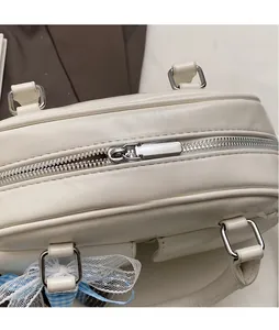 Detailed macro view of the silver smooth metal zipper and blue lace on the white Boston bag