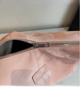 Macro shot of smooth pink faux leather tote with silver zipper and chevron fabric lining
