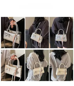 Dettagli della borsa a tracolla con fiocco e cinturino intrecciato in argento e bianco