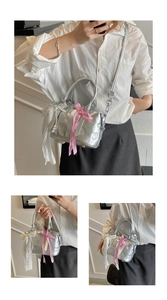 Detailed macro view of silver Boston bag with embossed patterns and pearl lace charm