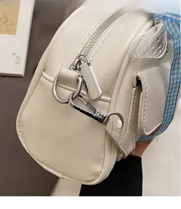 Detailed view of silver hardware hook and zipper on beige vintage Boston bag