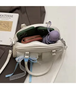 Interior view showing large capacity of the beige Boston bag with phone and umbrella