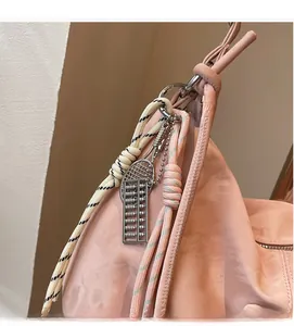 Detail of light pink tote bag featuring unique tennis racket and abacus charms