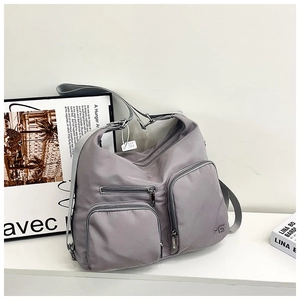 Detail einer lila Nylontasche mit Multi-Taschen-Design und wasserdichter Seidentextur