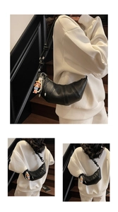 Détail du sac croissant en cuir noir avec bandoulière réglable et breloque en perles