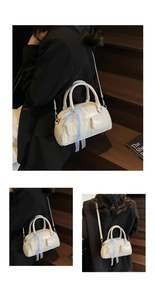 Detail of cream white Boston bag with blue lace bows and silver metal hardware