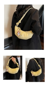 Détail du sac croissant jaune avec bandoulière à nœud et breloque poupée mignonne