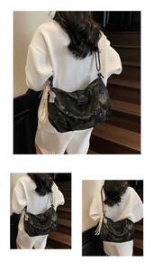 Detail of black tie-dye Hobo bag with braided handle and fashion metal brand plate