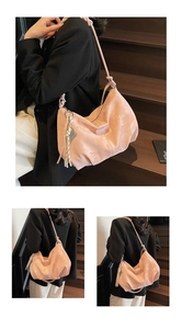 Pink satin hobo bag with woven strap shown on shoulder in lifestyle setting