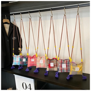 Close-up of retro plaid patchwork crossbody bags with colorful tassels and woven straps