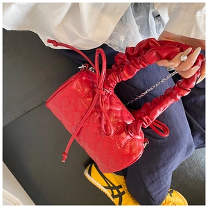 Gros plan du sac Boston rouge matelassé en cœur avec anse froncée et nœud coulissant