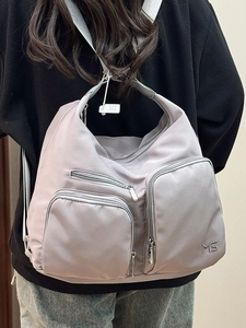 Vielseitige rauchgraue Nylon-Einkaufstasche mit mehreren Taschen an der Modelschulter