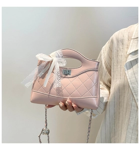 Close-up of pink quilted bucket bag with lace bow and silver chain strap details