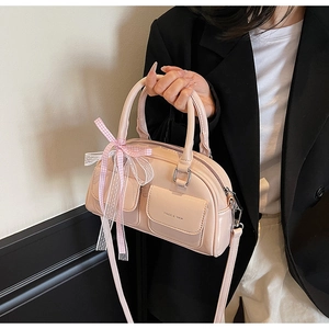 Detail of light pink patent leather Boston bag with pocket and lace checkered bow