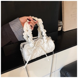Vue détaillée du sac polochon blanc avec matelassage cœur et poignée plissée élégante