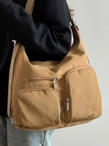 Khakifarbene Nylon-Umhängetasche mit vielen Taschen, am Modell für Alltag und Reise