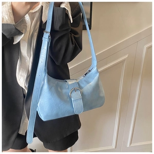 Close-up of light blue hobo bag with textured leather and a silver metal buckle detail
