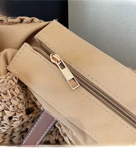 Detail view of smooth light gold metal zipper and stitching on straw tote bag