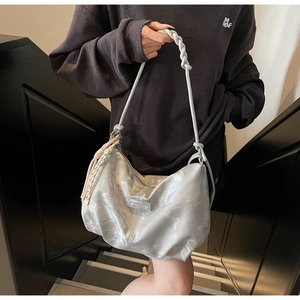 Silver metallic tote bag detail with woven strap and side fringe decoration