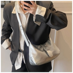 Detail of silver metallic hobo bag featuring crinkled texture and adjustable shoulder strap