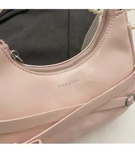 Close-up of pink crescent hobo bag with silver logo and smooth leather texture