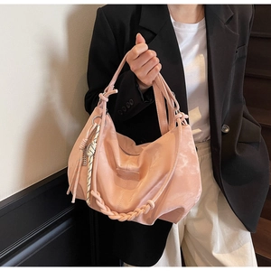 Pink nylon tote bag with unique woven rope detail and knotted handle shown in lifestyle shot