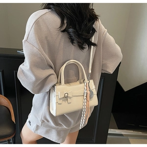 Borsa a tracolla con fiocco color bianco panna indossata da modella in ambiente sobrio
