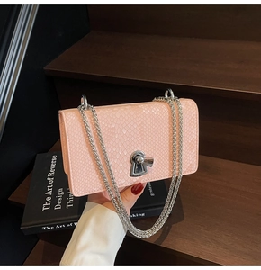 Detailed macro view of the light pink fish-scale texture and silver lock on this chain bag