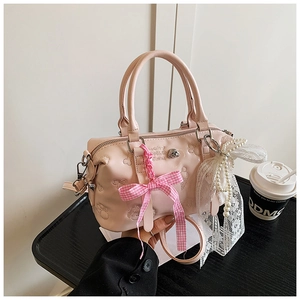 Detail of pink Boston bag featuring embossed bear motifs and lace pearl charm accessories