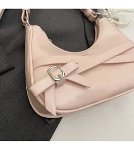 Pink crescent shoulder bag detail with elegant lace bow and silver buckle accents