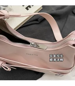 Detailed macro shot of the smooth silver zipper and glossy pink material of the bag