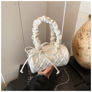 Détail du sac cylindre blanc matelassé en cœur avec nœud et poignée froncée