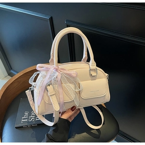 Detailed close-up of cream Boston bag featuring pink plaid bow and delicate lace trim