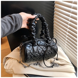 Détail du sac Boston noir avec surpiqûres en cœur et poignée plissée design