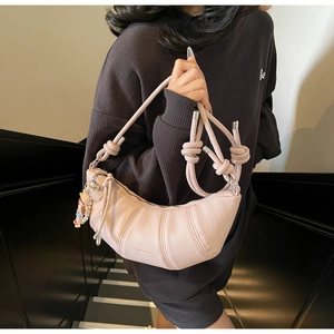 Détail du sac croissant rose montrant le cuir texturé et la bandoulière nouée