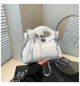 Detailed close-up of quilted pattern on white luxury bucket bag with lace bow