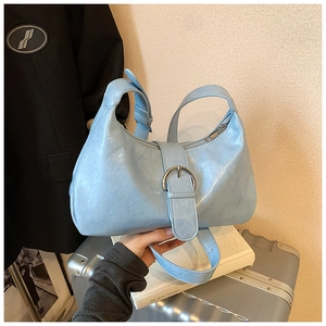 Close-up of light blue hobo bag with glossy wrinkled leather and silver buckle
