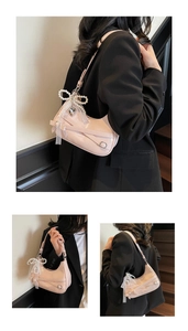 Detail of pink patent leather half-moon bag with lace, pearls and heart pendant