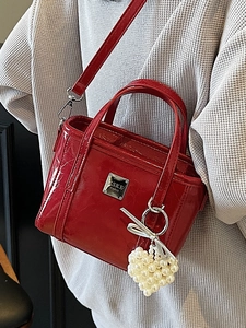 Borsa a secchiello in pelle verniciata rossa con ciondolo a cuore e tracolla rimovibile