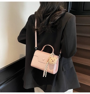 Pink textured PU leather crossbody bag featuring a plush bear charm and polka dot scarf detail