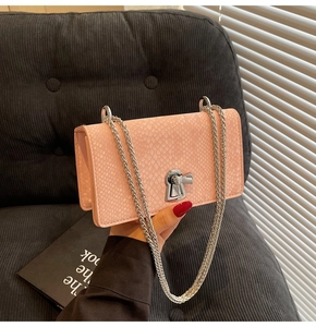 Close-up of pink snake pattern embossed faux leather bag with silver metal chain