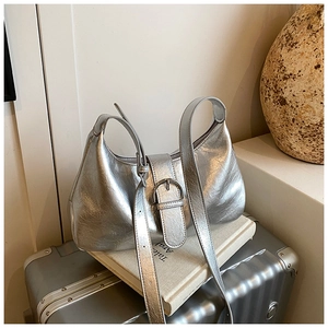 Detail of silver metallic hobo bag featuring glossy wrinkled leather and round buckle