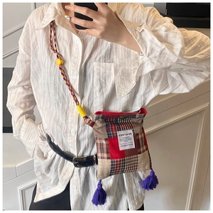 Detail of retro plaid crossbody bag with purple fringe tassel and colorful woven strap