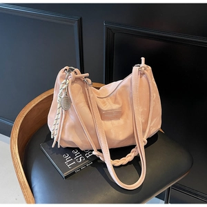 Detail of pink ruched tote bag with woven strap and tennis racket pendant