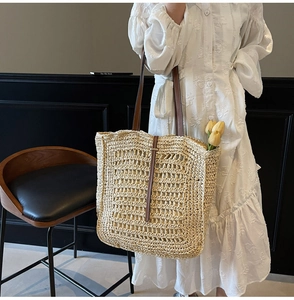 Detail of hollow-out woven straw tote bag with leather straps for beach holidays